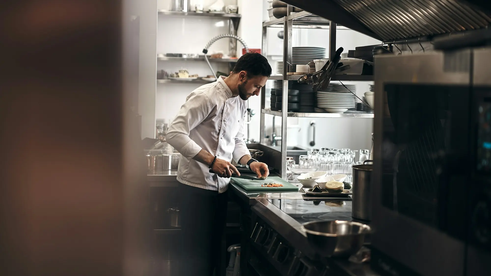 A chef preparing vegetables in a restaurant kitchen