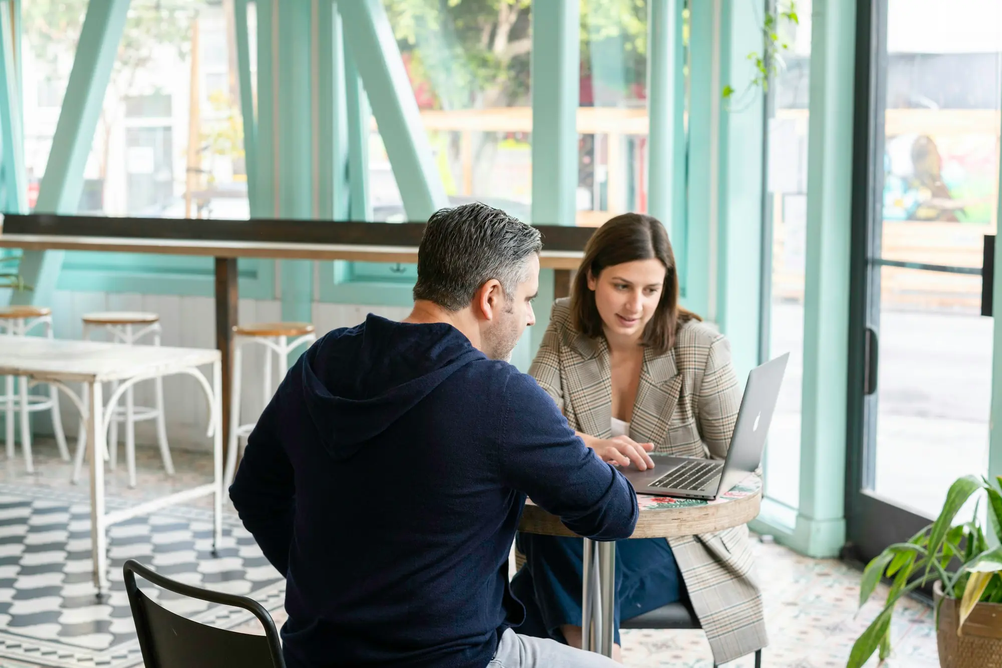 Two people reviewing figures together on a laptop